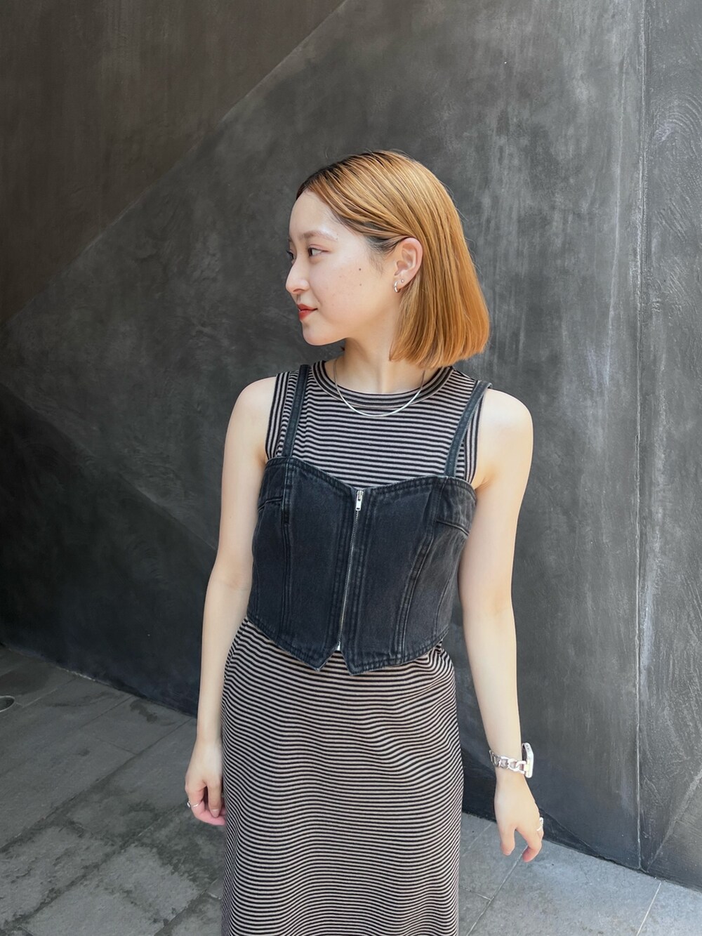 ブラウン系のワンピース、ブラック系のベスト、ブラック系のサンダルを着用したレディースの夏コーディネートの4枚目の写真