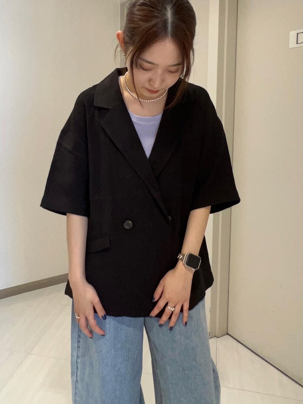 ブルー系のデニムパンツ、ブラック系のローファー、ブラック系のテーラードジャケットを着用したレディースの春コーディネートの5枚目の写真