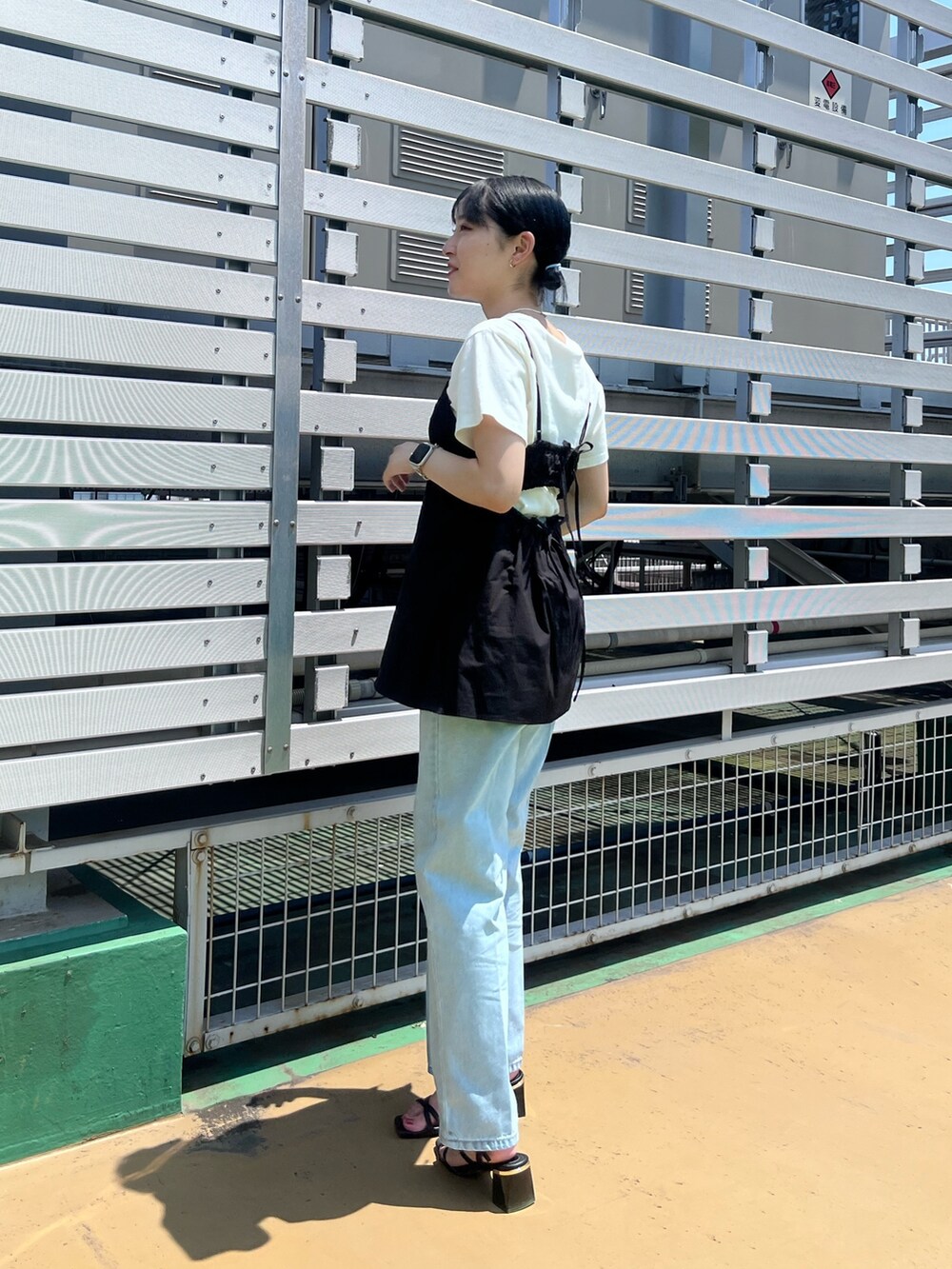 ホワイト系のTシャツ/カットソー、ブラック系のシャツ/ブラウス、ブルー系のデニムパンツを着用したレディースの夏コーディネートの3枚目の写真