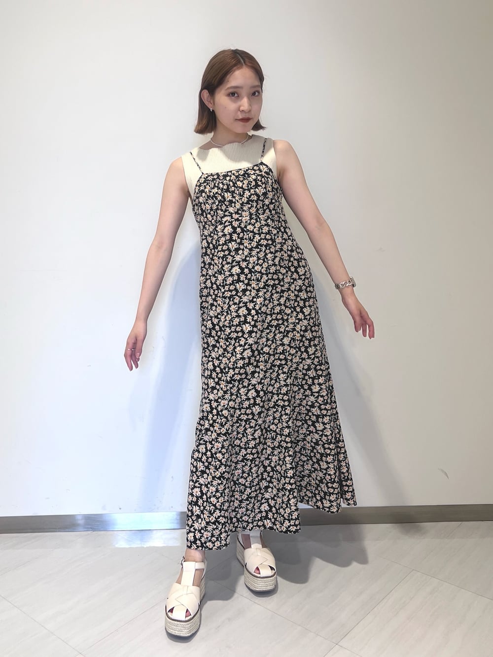 ブラック系のワンピース、ホワイト系のニット/セーター、ホワイト系のサンダルを着用したレディースの夏コーディネートの2枚目の写真
