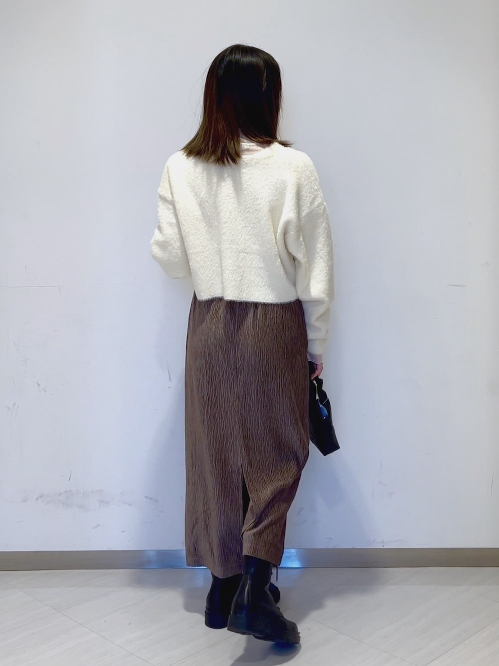 ホワイト系のTシャツ/カットソー、ホワイト系のカーディガン/ボレロ、ブラック系のショルダーバッグを着用したレディースの冬コーディネートの5枚目の写真