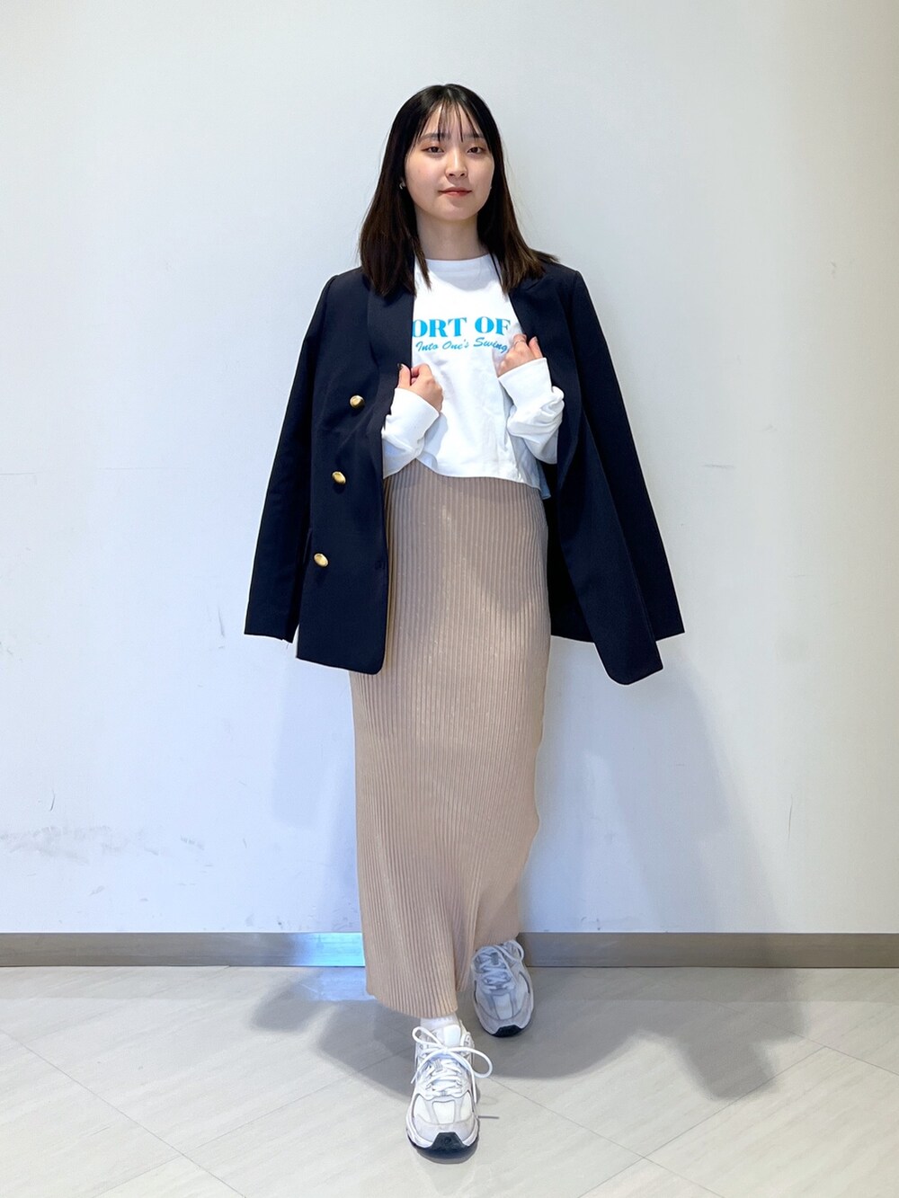 ホワイト系のTシャツ/カットソー、ブルー系のテーラードジャケット、ゴールド系のスカートを着用したレディースの冬コーディネートの4枚目の写真