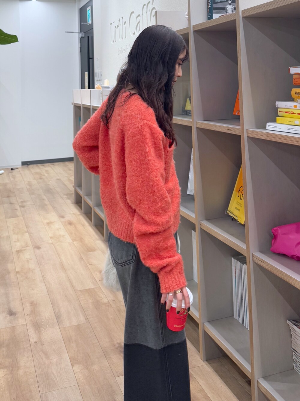 ピンク系のカーディガン/ボレロ、ブラック系のデニムパンツ、ベージュ系のショルダーバッグを着用したレディースの冬コーディネートの4枚目の写真