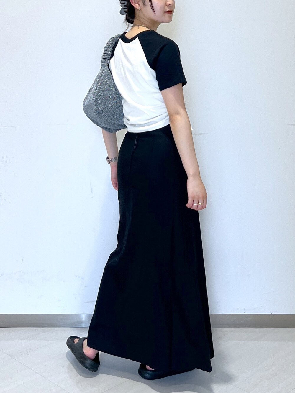 ホワイト系のTシャツ/カットソー、シルバー系のハンドバッグ、ブラック系のスカートを着用したレディースの夏コーディネートの4枚目の写真