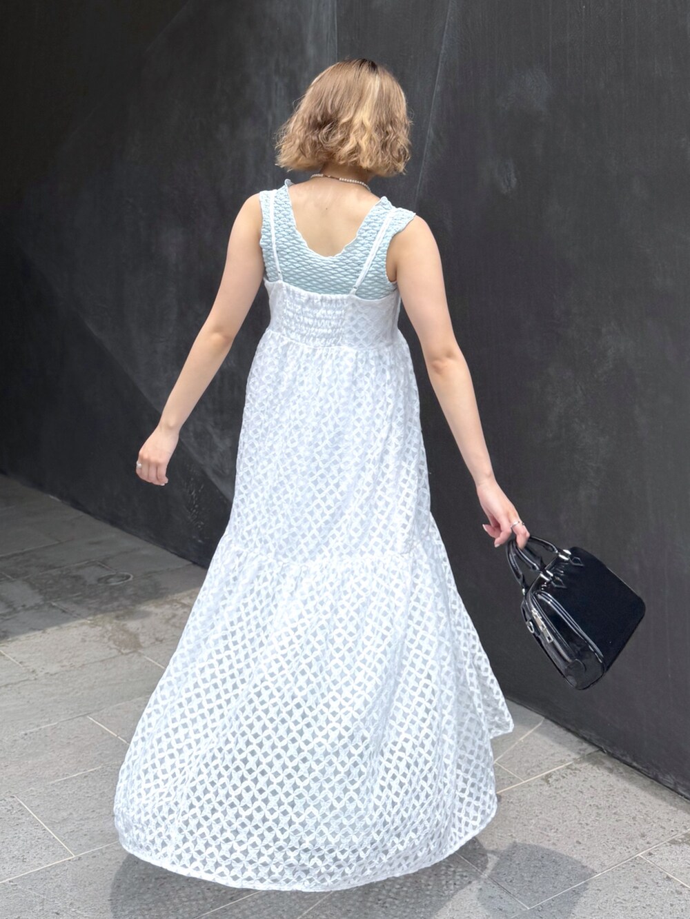 ブルー系のタンクトップ、ホワイト系のワンピース、ブルー系のデニムパンツを着用したレディースの夏コーディネートの5枚目の写真