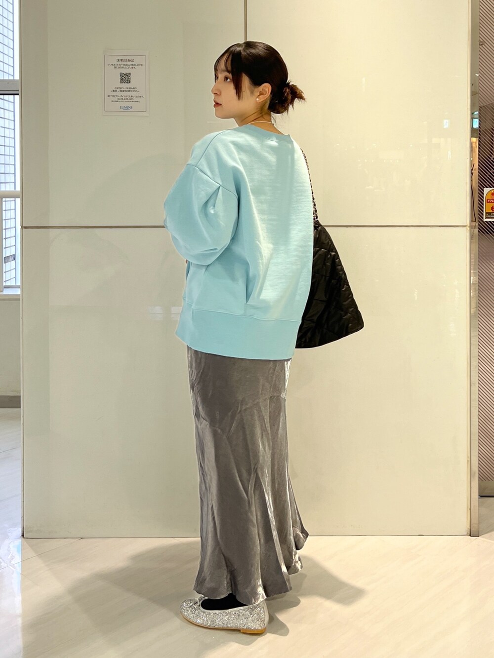 ブラック系のトートバッグ、ブラック系のスカート、ブルー系のスウェットを着用したレディースの冬コーディネートの5枚目の写真