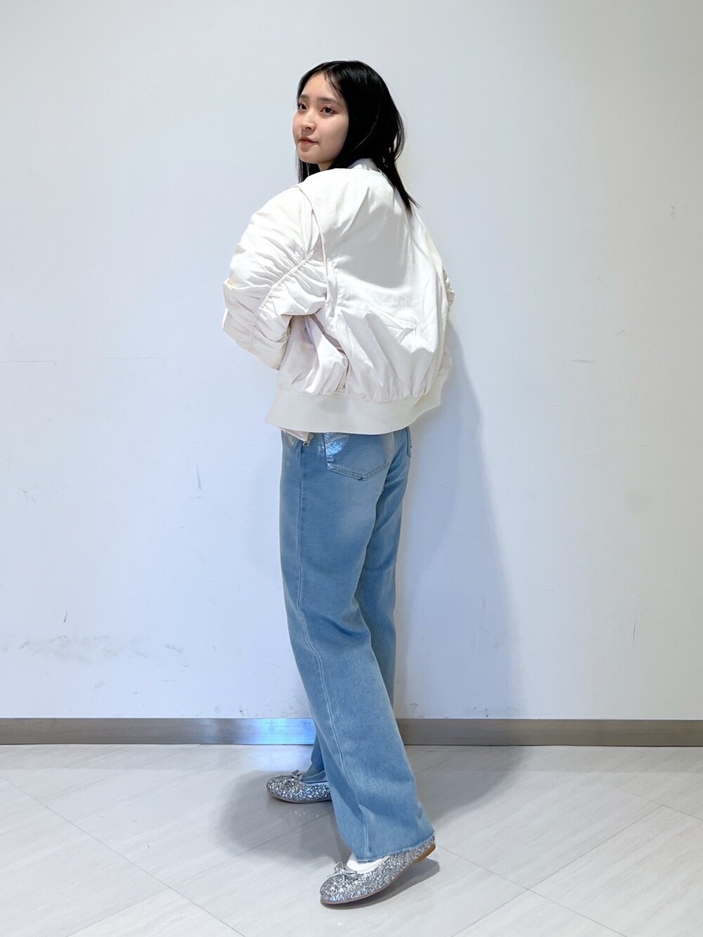 ホワイト系のMA-1、ホワイト系のニット/セーター、ブルー系のデニムパンツを着用したレディースの冬コーディネートの5枚目の写真