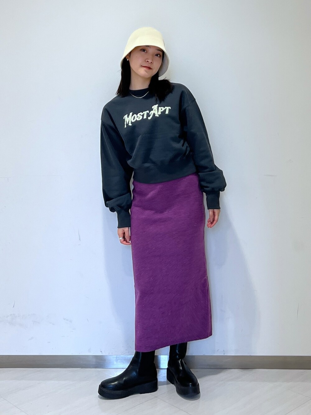 ブラック系のスウェット、パープル系のスカート、ベージュ系のハットを着用したレディースの冬コーディネートの2枚目の写真