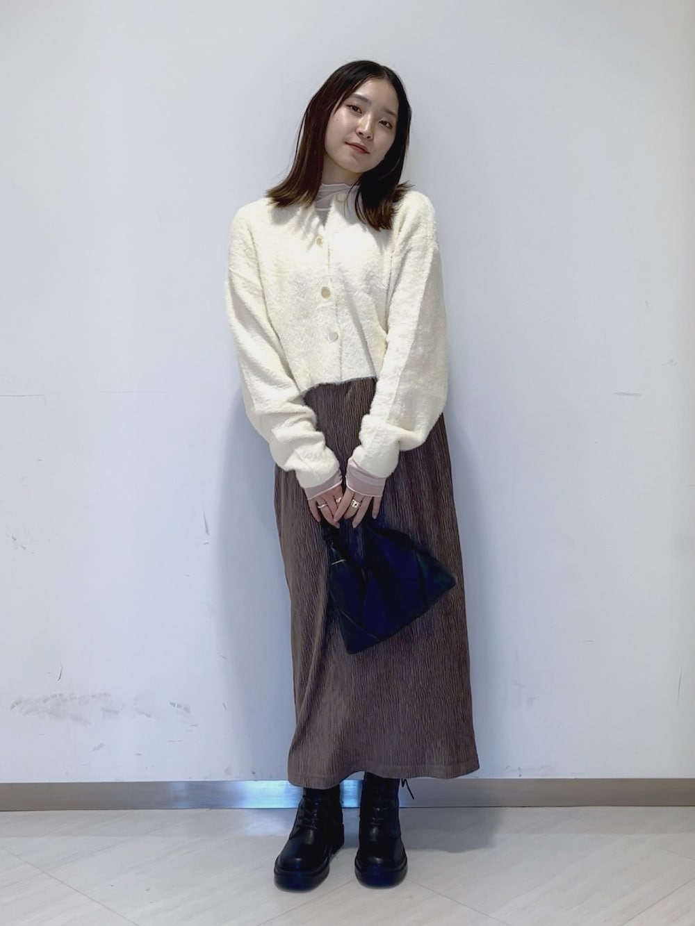 ホワイト系のTシャツ/カットソー、ホワイト系のカーディガン/ボレロ、ブラック系のショルダーバッグを着用したレディースの冬コーディネートの2枚目の写真