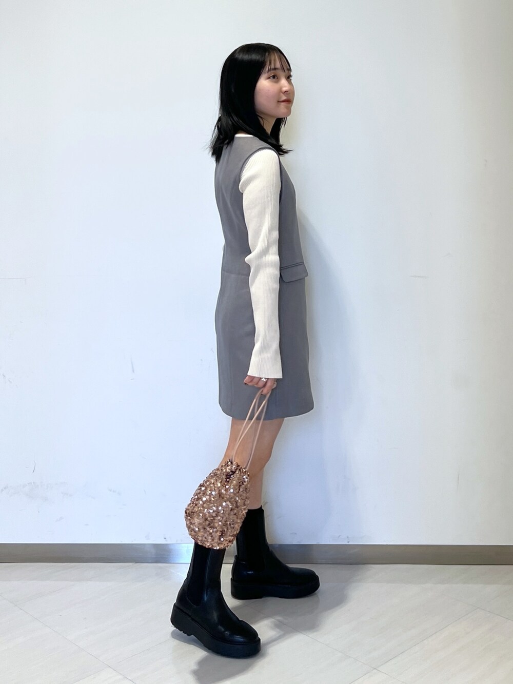 ホワイト系のニット/セーター、グレー系のワンピース、ピンク系のハンドバッグを着用したレディースの春コーディネートの3枚目の写真