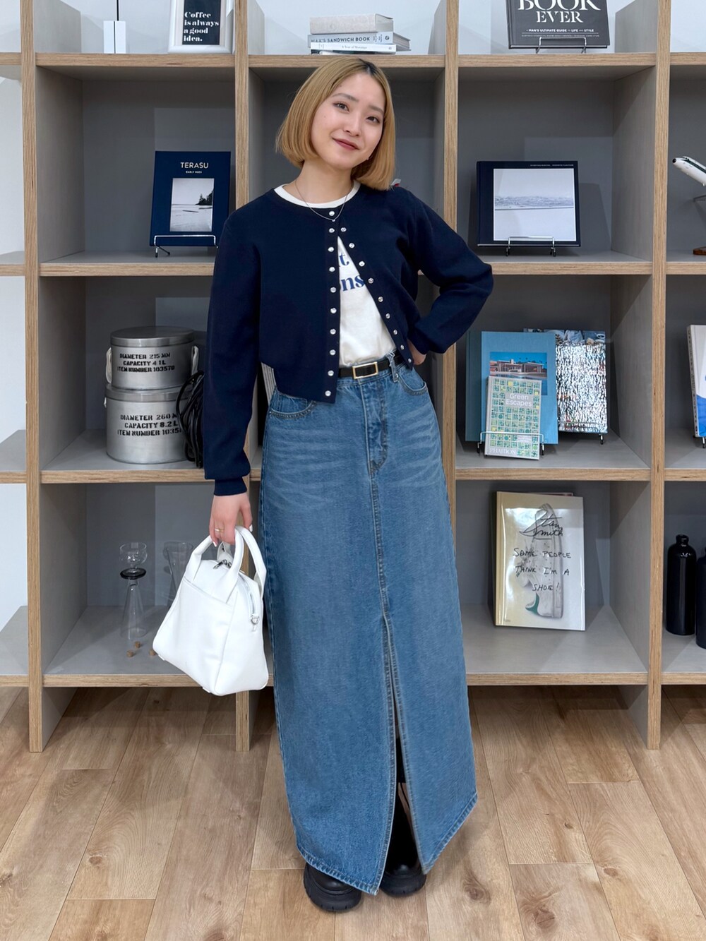 ブルー系のカーディガン/ボレロ、ホワイト系のTシャツ/カットソー、ブルー系のデニムスカートを着用したレディースの春コーディネートの3枚目の写真