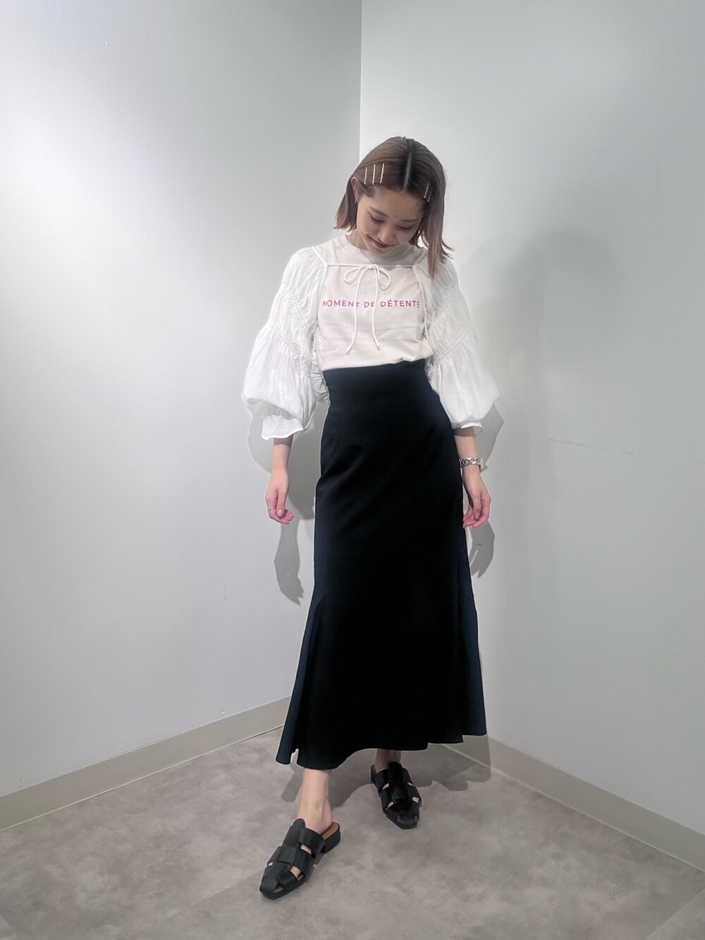 ブラック系のスカート、ホワイト系のカーディガン/ボレロ、ホワイト系のTシャツ/カットソーを着用したレディースの夏コーディネートの2枚目の写真