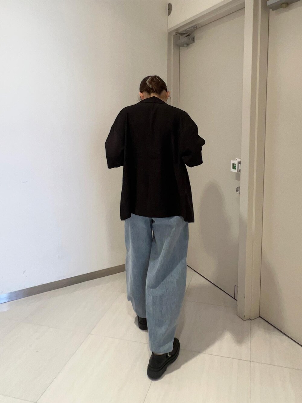 ブルー系のデニムパンツ、ブラック系のローファー、ブラック系のテーラードジャケットを着用したレディースの春コーディネートの4枚目の写真