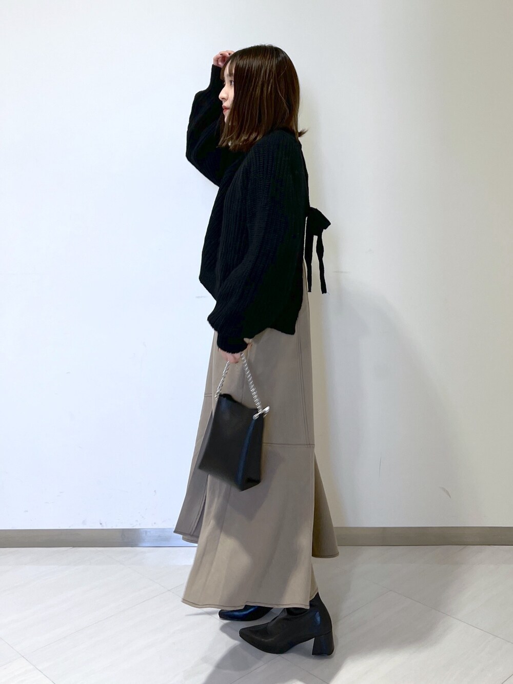 ブラック系のタンクトップ、ブラック系のニット/セーター、ブラウン系のワンピースを着用したレディースの秋コーディネートの3枚目の写真