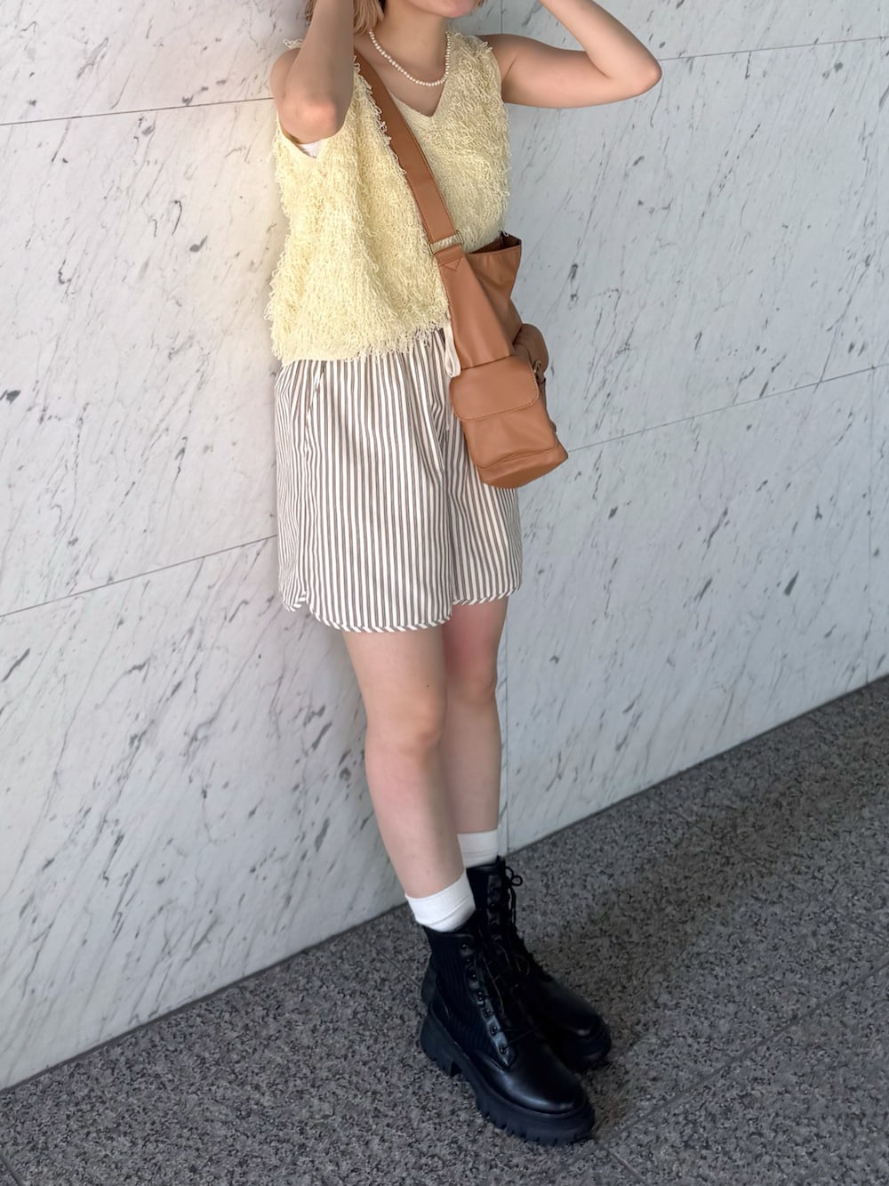 イエロー系のニット/セーター、ブラウン系のトートバッグ、ブラウン系のその他パンツを着用したレディースの夏コーディネートの4枚目の写真