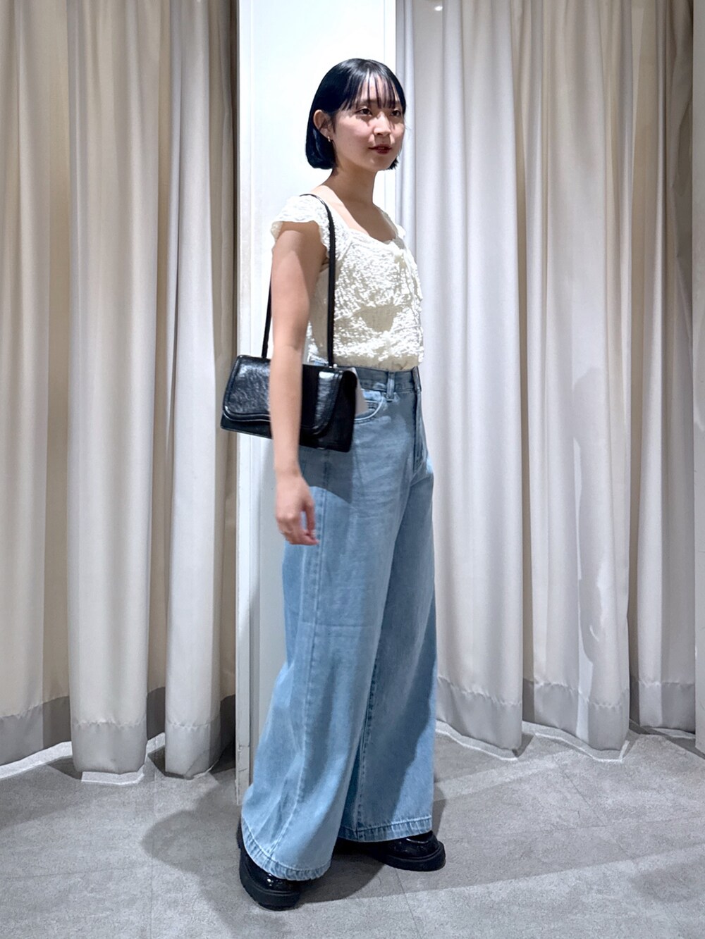 ホワイト系のTシャツ/カットソー、ブラック系のショルダーバッグ、ブルー系のデニムパンツを着用したレディースの夏コーディネートの2枚目の写真