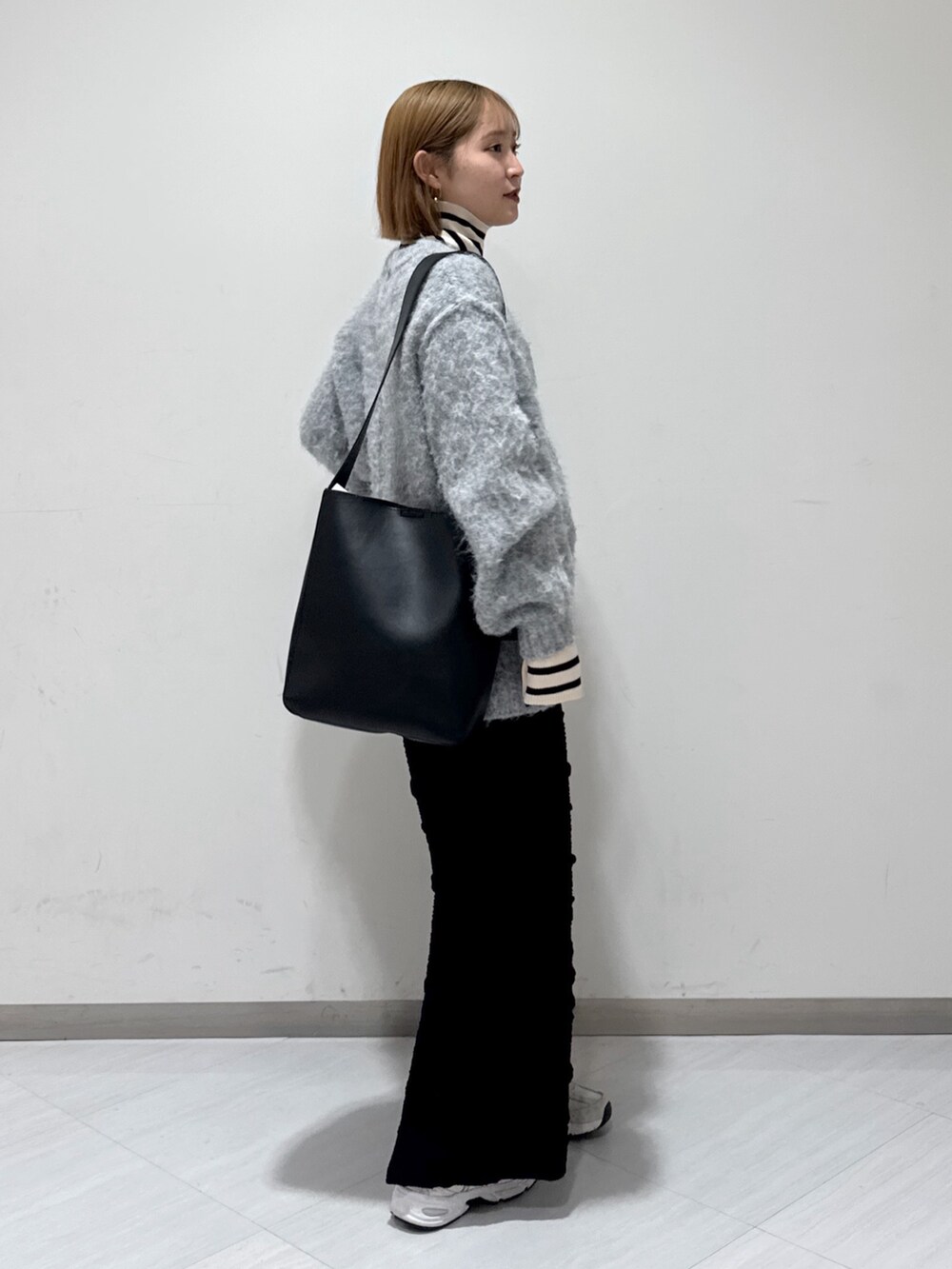 ホワイト系のダウンジャケット/コート、グレー系のニット/セーター、ベージュ系のニット/セーターを着用したレディースの冬コーディネートの4枚目の写真