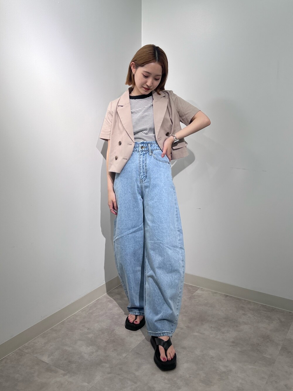 ベージュ系のテーラードジャケット、ブラック系のTシャツ/カットソー、ブルー系のデニムパンツを着用したレディースの夏コーディネートの2枚目の写真