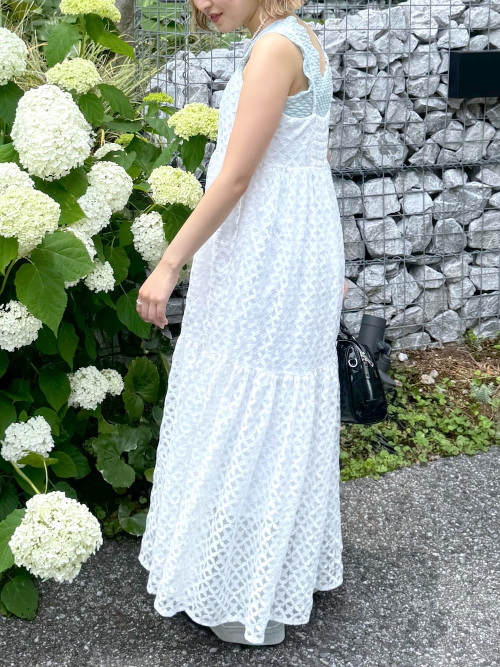 ブルー系のタンクトップ、ホワイト系のワンピース、ブルー系のデニムパンツを着用したレディースの夏コーディネートの3枚目の写真