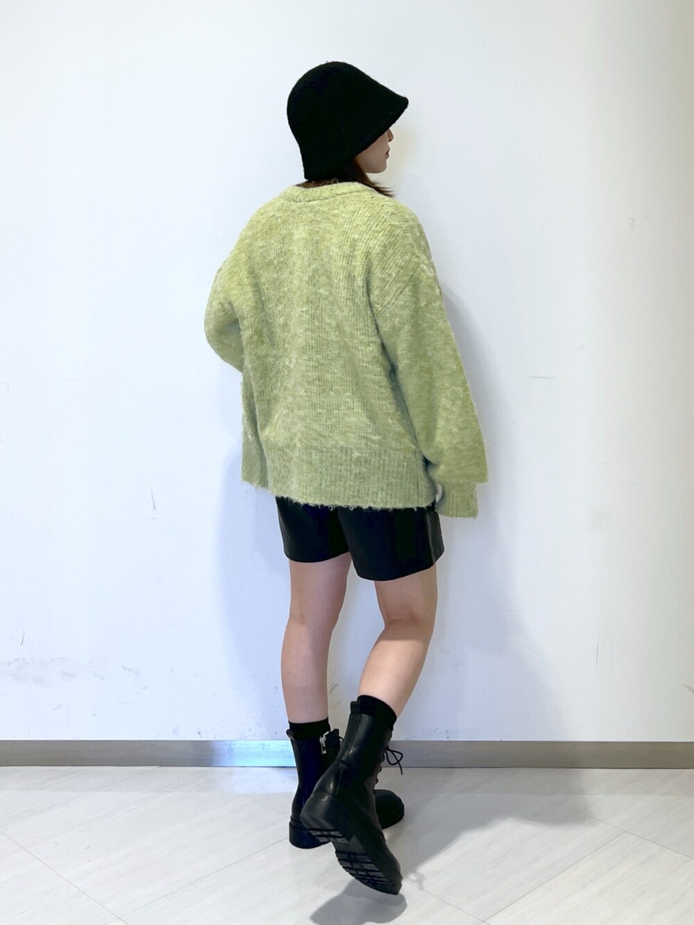 ブラック系のTシャツ/カットソー、グリーン系のニット/セーター、ブラック系のその他パンツを着用したレディースの冬コーディネートの5枚目の写真