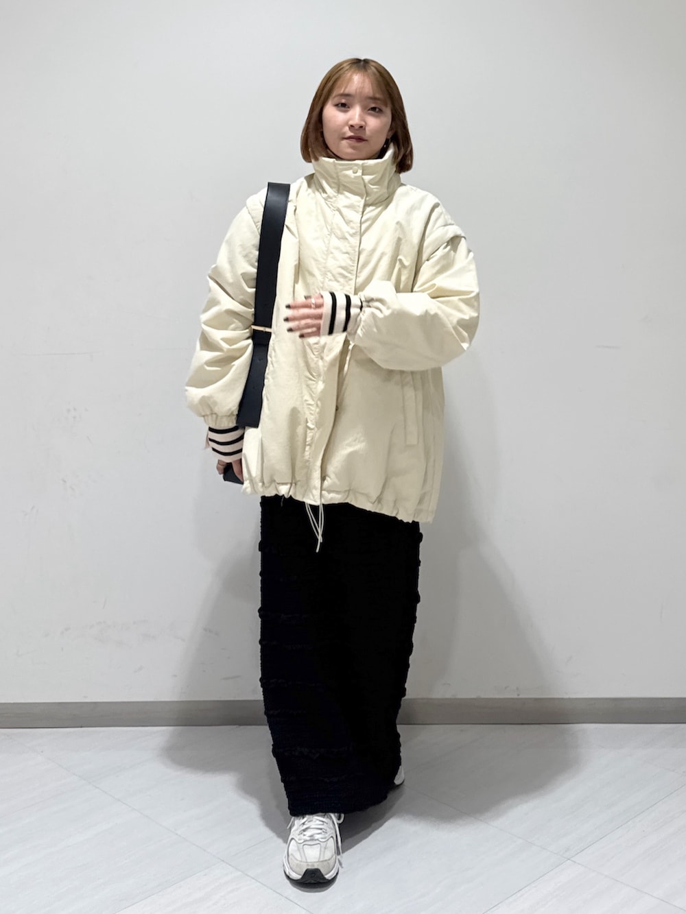 ホワイト系のダウンジャケット/コート、グレー系のニット/セーター、ベージュ系のニット/セーターを着用したレディースの冬コーディネートの3枚目の写真