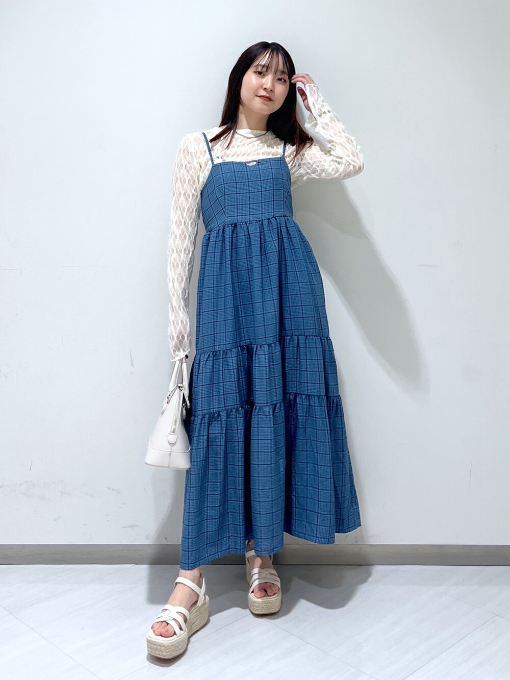 ホワイト系のショルダーバッグ、ブルー系のワンピース、ホワイト系のカーディガン/ボレロを着用したレディースの春コーディネートの2枚目の写真