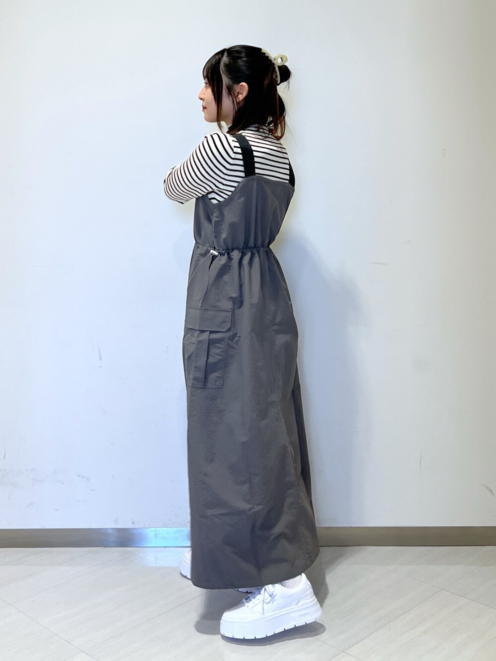 グレー系のワンピース、ホワイト系のハンドバッグ、ホワイト系のニット/セーターを着用したレディースの冬コーディネートの2枚目の写真