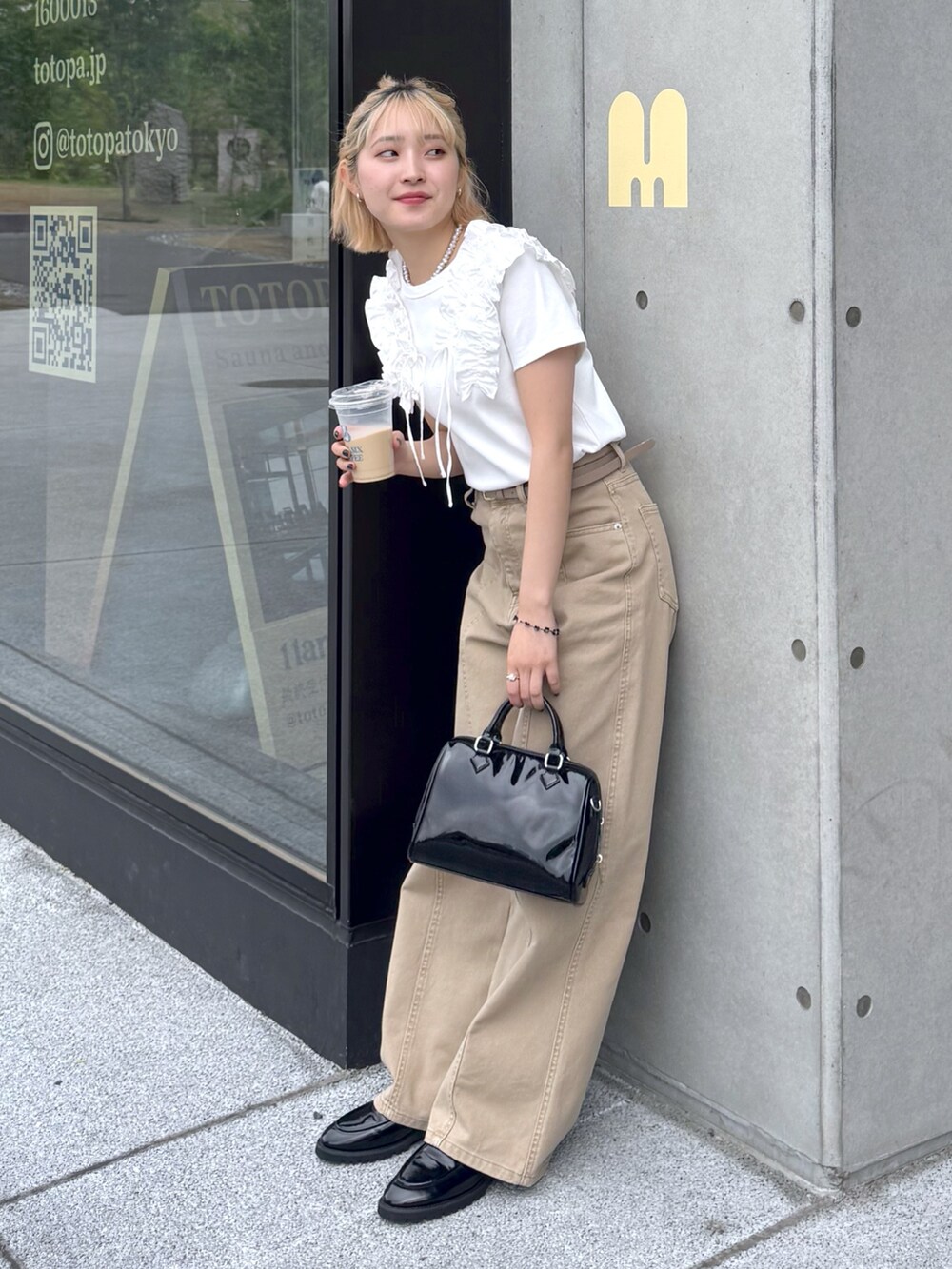 ホワイト系のTシャツ/カットソー、ベージュ系のその他パンツ、ブラック系のショルダーバッグを着用したレディースの春コーディネートの2枚目の写真