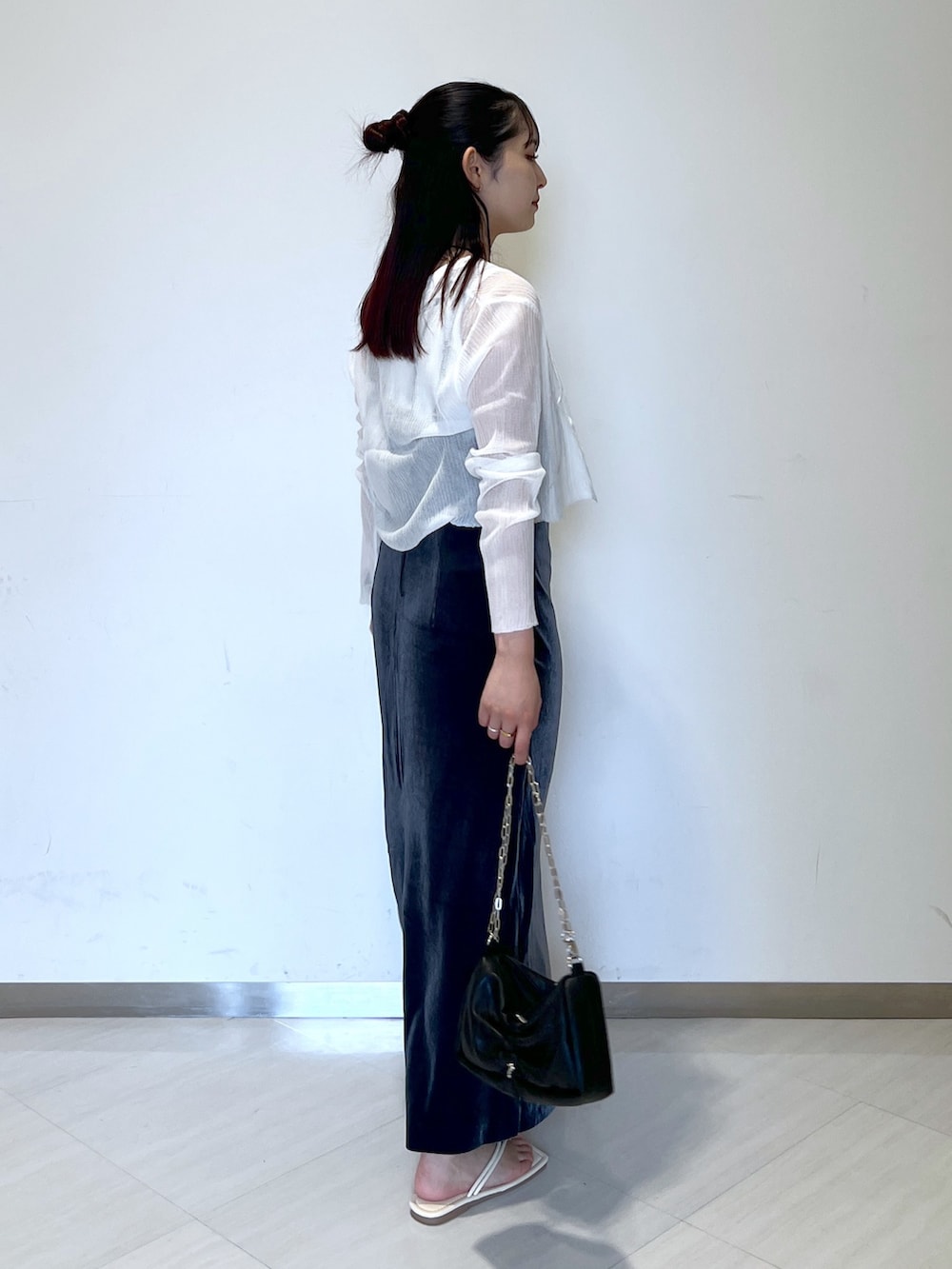 グレー系のワンピース、ホワイト系のタンクトップ、ホワイト系のカーディガン/ボレロを着用したレディースの夏コーディネートの2枚目の写真