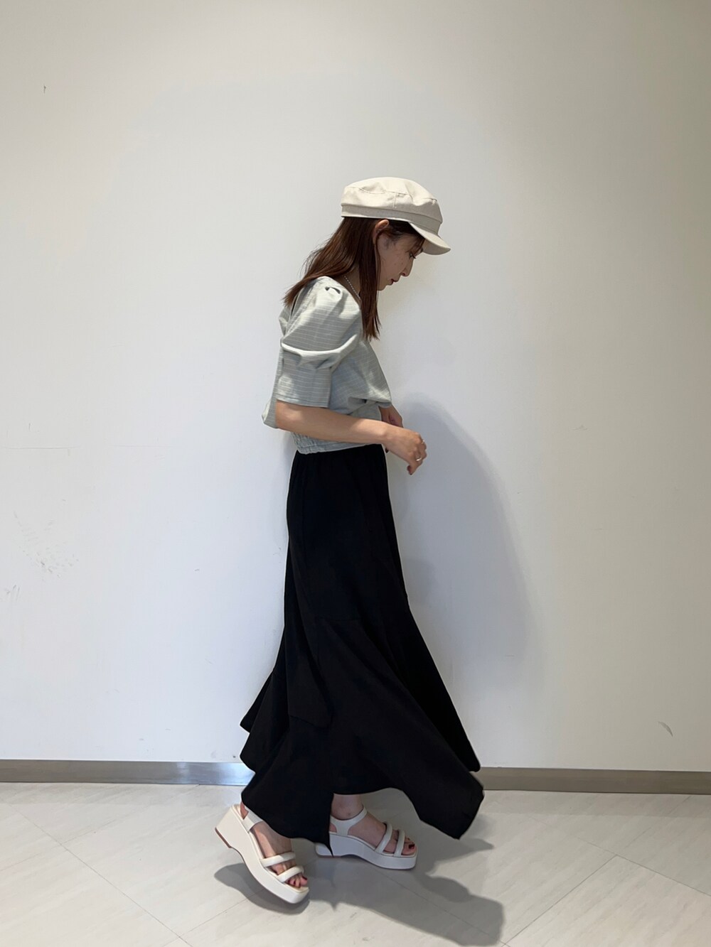 ブルー系のシャツ/ブラウス、ブラック系のスカート、ホワイト系のサンダルを着用したレディースの春コーディネートの2枚目の写真