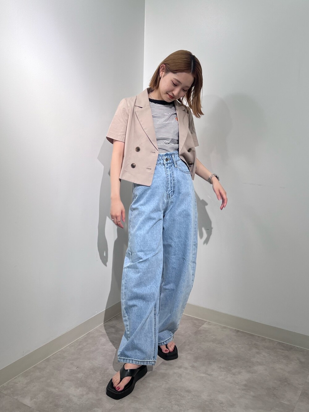 ベージュ系のテーラードジャケット、ブラック系のTシャツ/カットソー、ブルー系のデニムパンツを着用したレディースの夏コーディネートの3枚目の写真