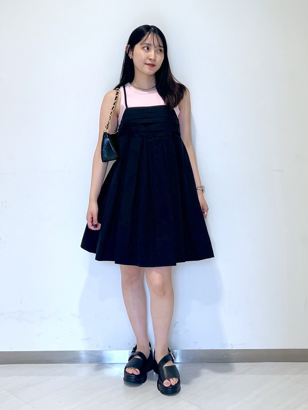 ピンク系のタンクトップ、ブラック系のワンピース、ブラック系のトートバッグを着用したレディースの夏コーディネートの2枚目の写真