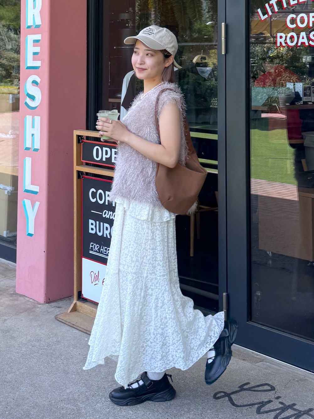 ホワイト系のワンピース、ベージュ系のニット/セーター、ブラウン系のハンドバッグを着用したレディースの夏コーディネートの2枚目の写真