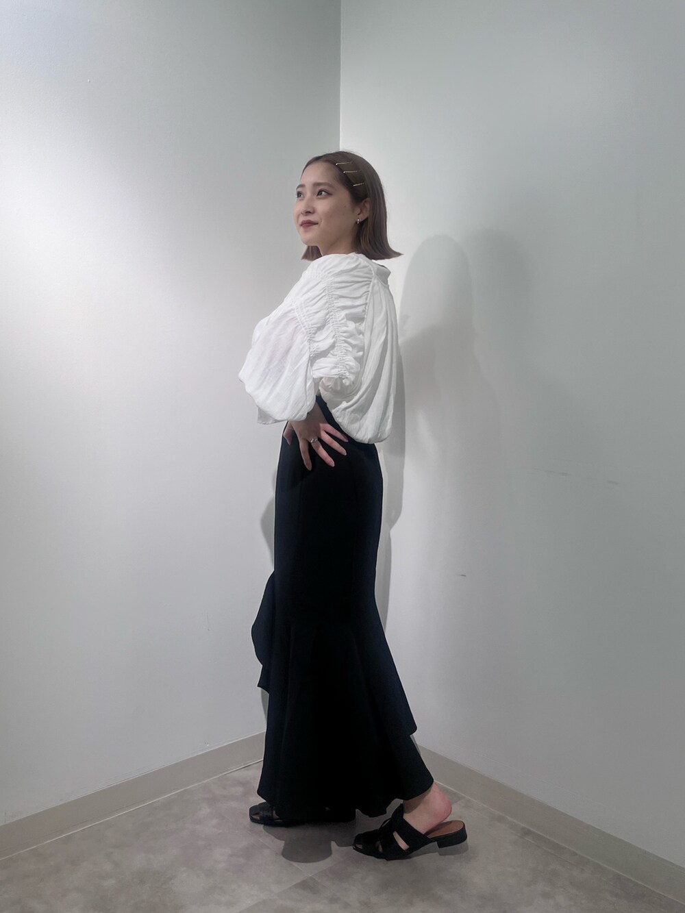 ブラック系のスカート、ホワイト系のカーディガン/ボレロ、ホワイト系のTシャツ/カットソーを着用したレディースの夏コーディネートの3枚目の写真