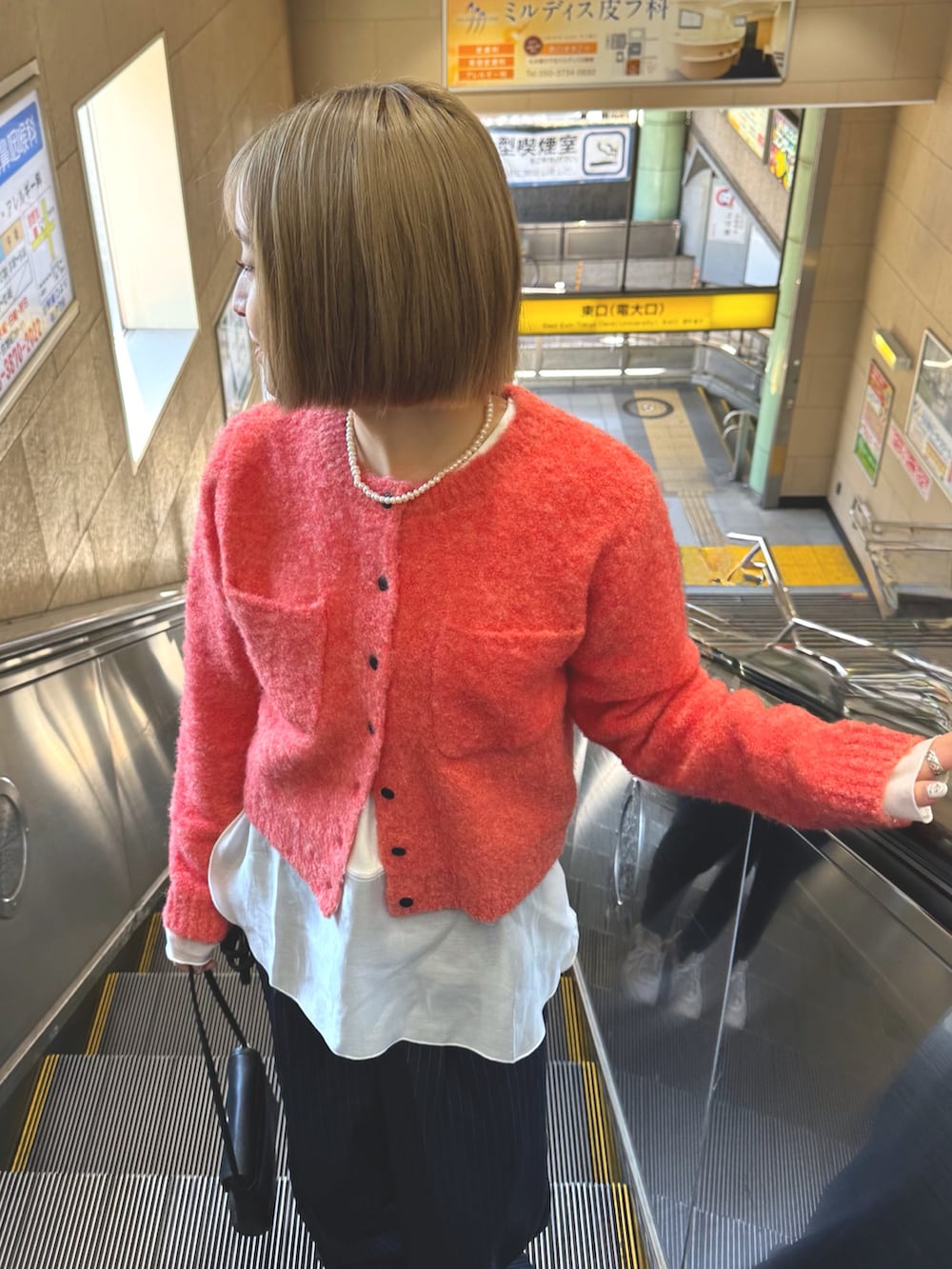 ホワイト系のTシャツ/カットソー、ピンク系のカーディガン/ボレロ、ブルー系のスラックスを着用したレディースの冬コーディネートの4枚目の写真