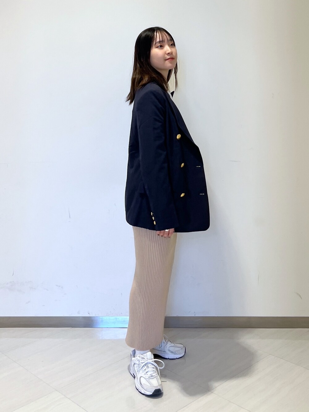 ホワイト系のTシャツ/カットソー、ブルー系のテーラードジャケット、ゴールド系のスカートを着用したレディースの冬コーディネートの3枚目の写真