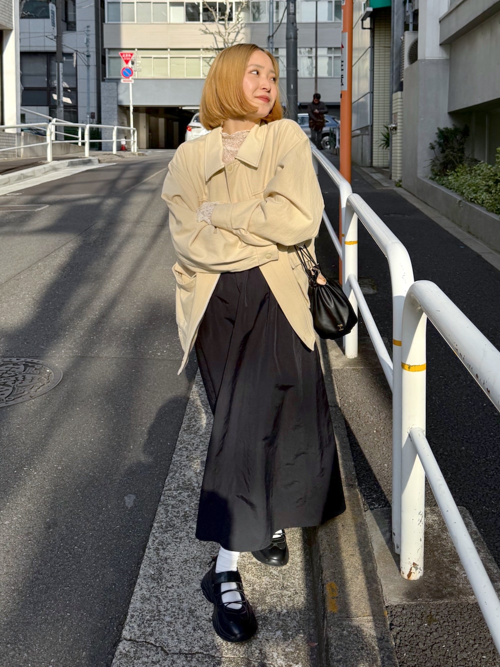 ホワイト系のその他アウター、ホワイト系のTシャツ/カットソー、ブラック系のジャンパースカートを着用したレディースの春コーディネートの4枚目の写真