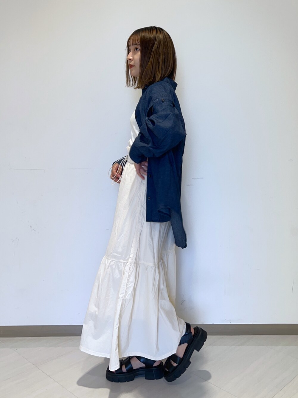 ホワイト系のタンクトップ、ブルー系のシャツ/ブラウス、ホワイト系のスカートを着用したレディースの秋コーディネートの2枚目の写真