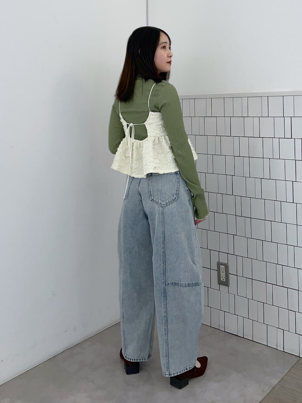 グリーン系のTシャツ/カットソー、ホワイト系のシャツ/ブラウス、ブルー系のデニムパンツを着用したレディースの春コーディネートの2枚目の写真