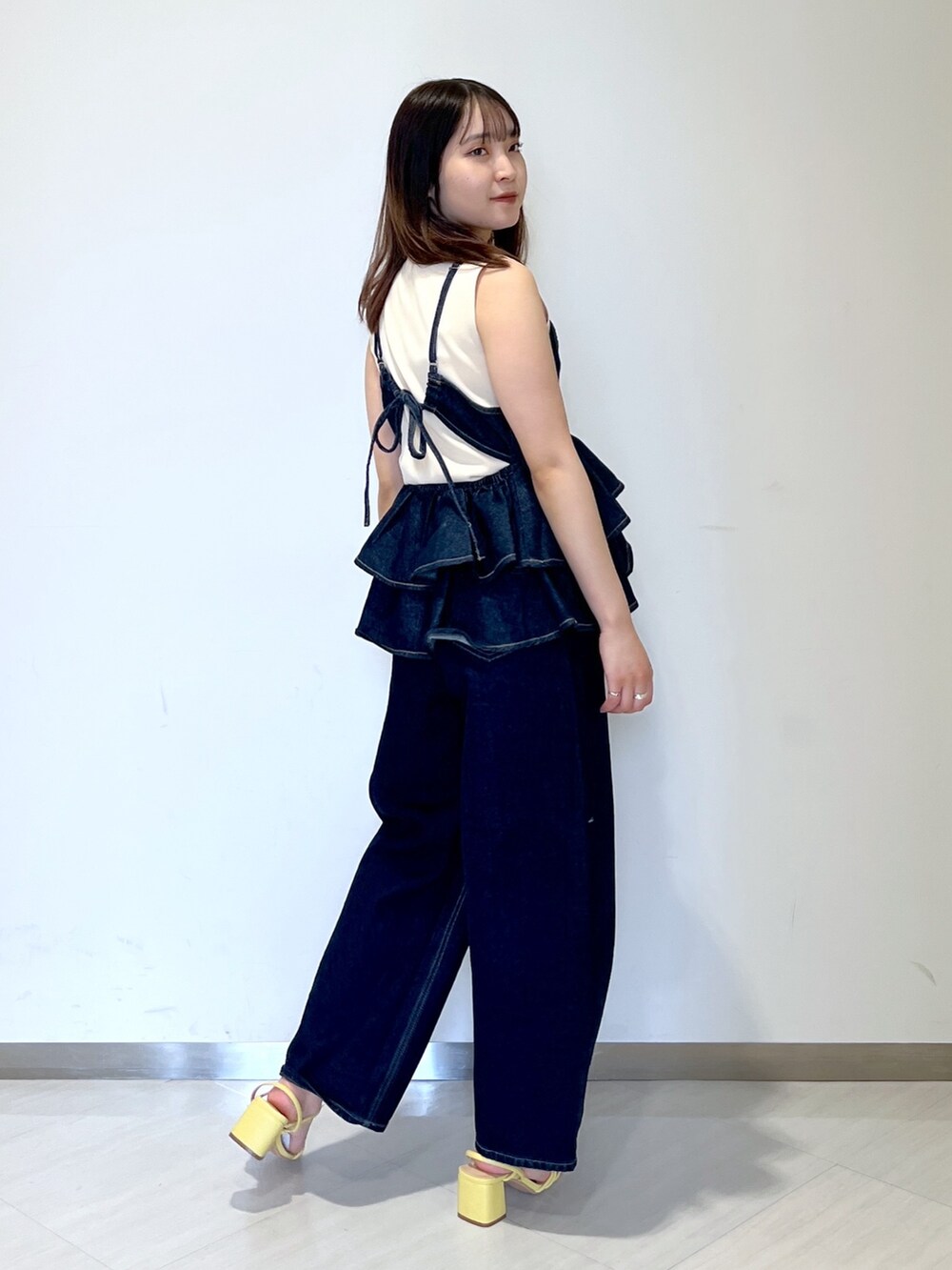 ホワイト系のニット/セーター、ブルー系のベスト、ブルー系のデニムパンツを着用したレディースの春コーディネートの3枚目の写真