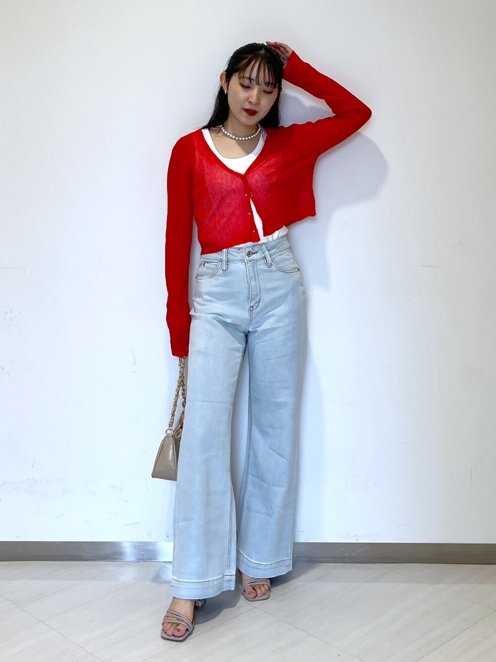 ブルー系のデニムパンツ、ベージュ系のトートバッグ、グレー系のサンダルを着用したレディースの夏コーディネートの2枚目の写真