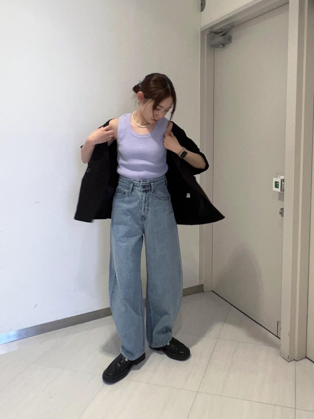 ブルー系のデニムパンツ、ブラック系のローファー、ブラック系のテーラードジャケットを着用したレディースの春コーディネートの2枚目の写真