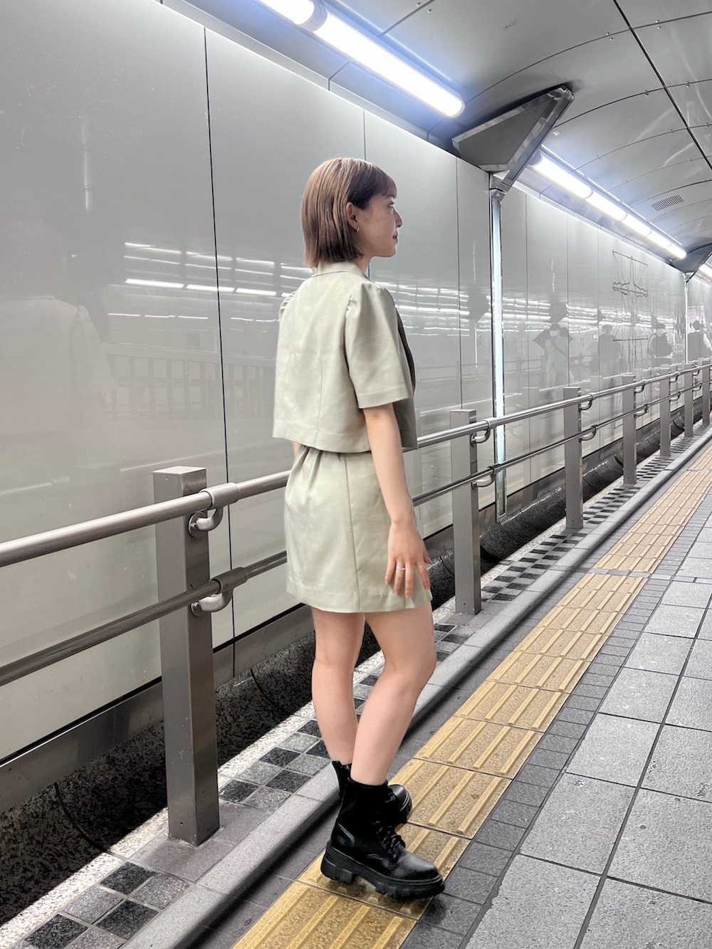 ベージュ系のテーラードジャケット、パープル系のTシャツ/カットソー、ベージュ系のスカートを着用したレディースの春コーディネートの2枚目の写真