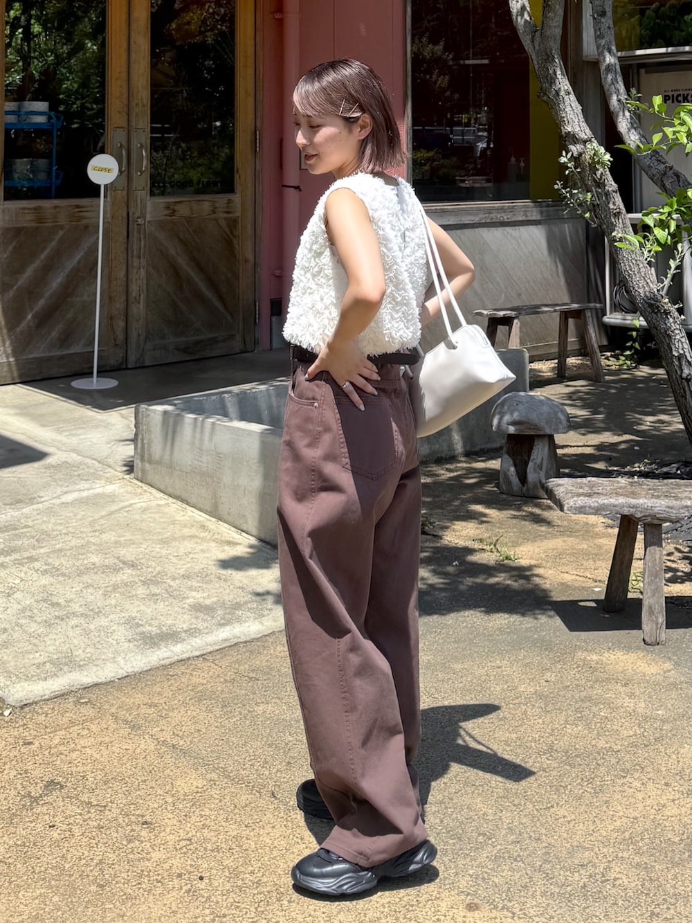 ホワイト系のシャツ/ブラウス、ブラウン系のデニムパンツ、ブラック系のスニーカーを着用したレディースの夏コーディネートの2枚目の写真