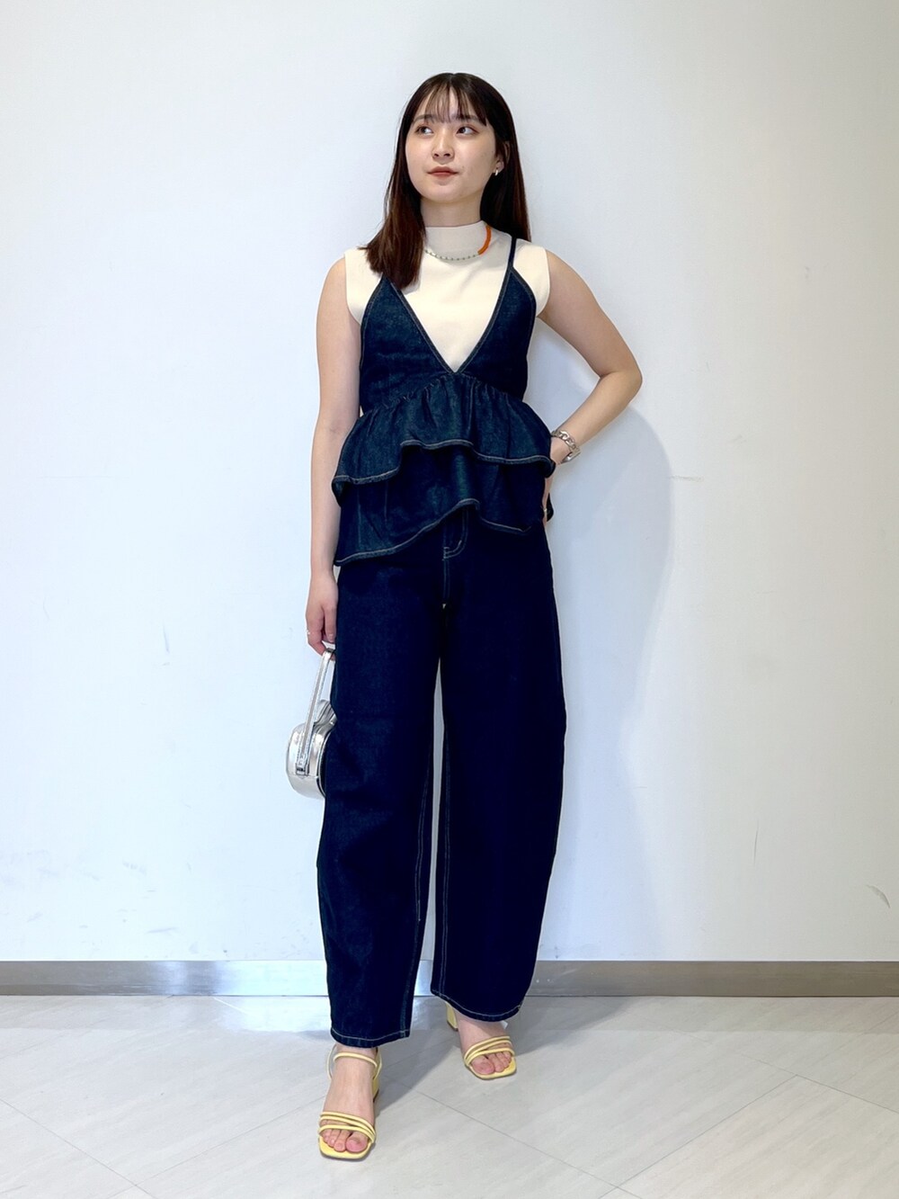 ホワイト系のニット/セーター、ブルー系のベスト、ブルー系のデニムパンツを着用したレディースの春コーディネートの2枚目の写真