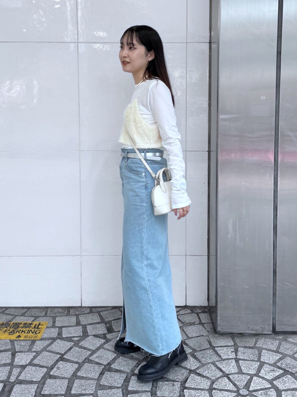 ブルー系のデニムスカート、ブラック系のブーツ、ホワイト系のキャミソールを着用したレディースの夏コーディネートの4枚目の写真