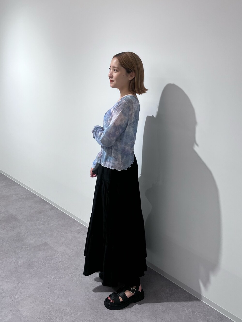 ブラック系のトートバッグ、ブラック系のスカート、ブラック系のサンダルを着用したレディースの夏コーディネートの4枚目の写真