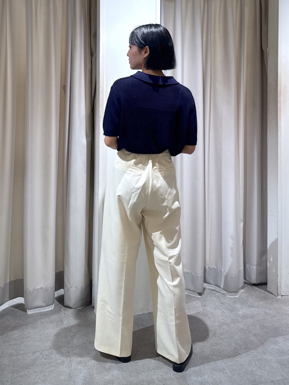 ブルー系のニット/セーター、ホワイト系のスラックス、ホワイト系のショルダーバッグを着用したレディースの夏コーディネートの5枚目の写真