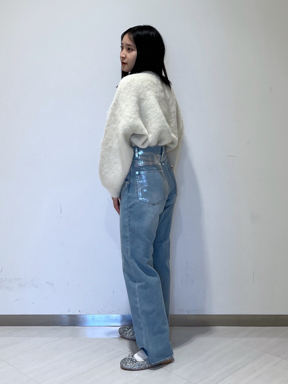 ホワイト系のMA-1、ホワイト系のニット/セーター、ブルー系のデニムパンツを着用したレディースの冬コーディネートの4枚目の写真