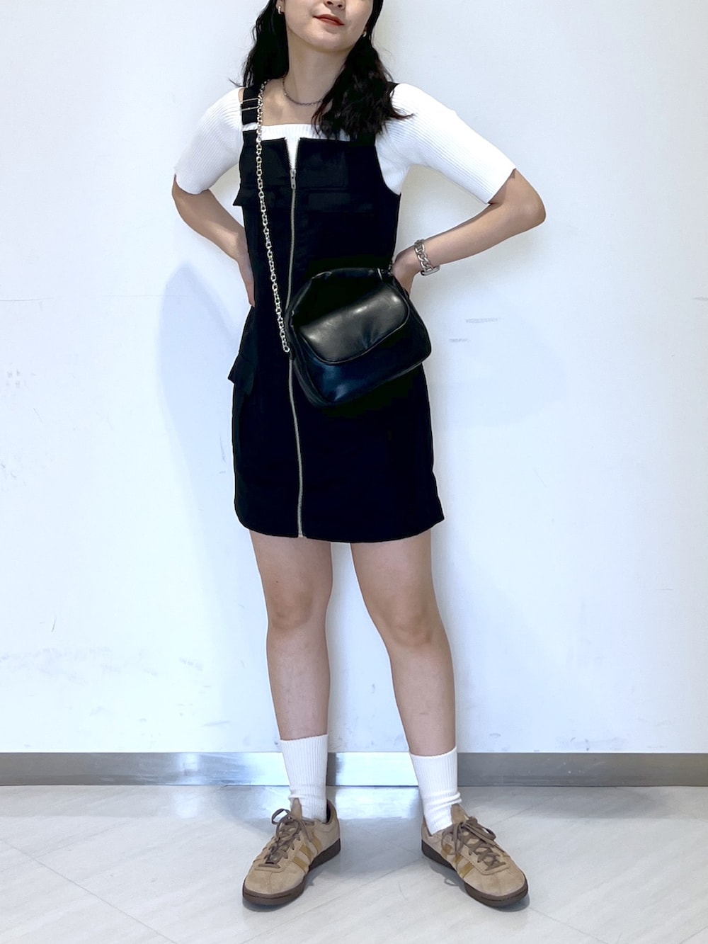 ブラック系のワンピース、ホワイト系のニット/セーター、ブラック系のショルダーバッグを着用したレディースの夏コーディネートの2枚目の写真